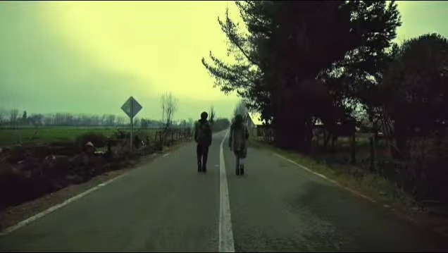 Fotograma de Blue Angel: dos personajes caminan por un camino rural