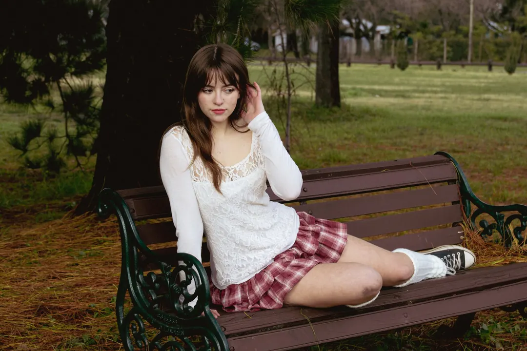 Joven sentada en una banca del parque