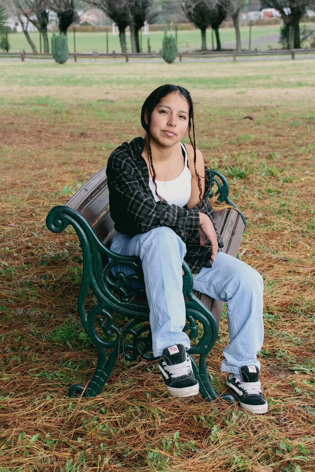 Joven sentada en una banca de fierro