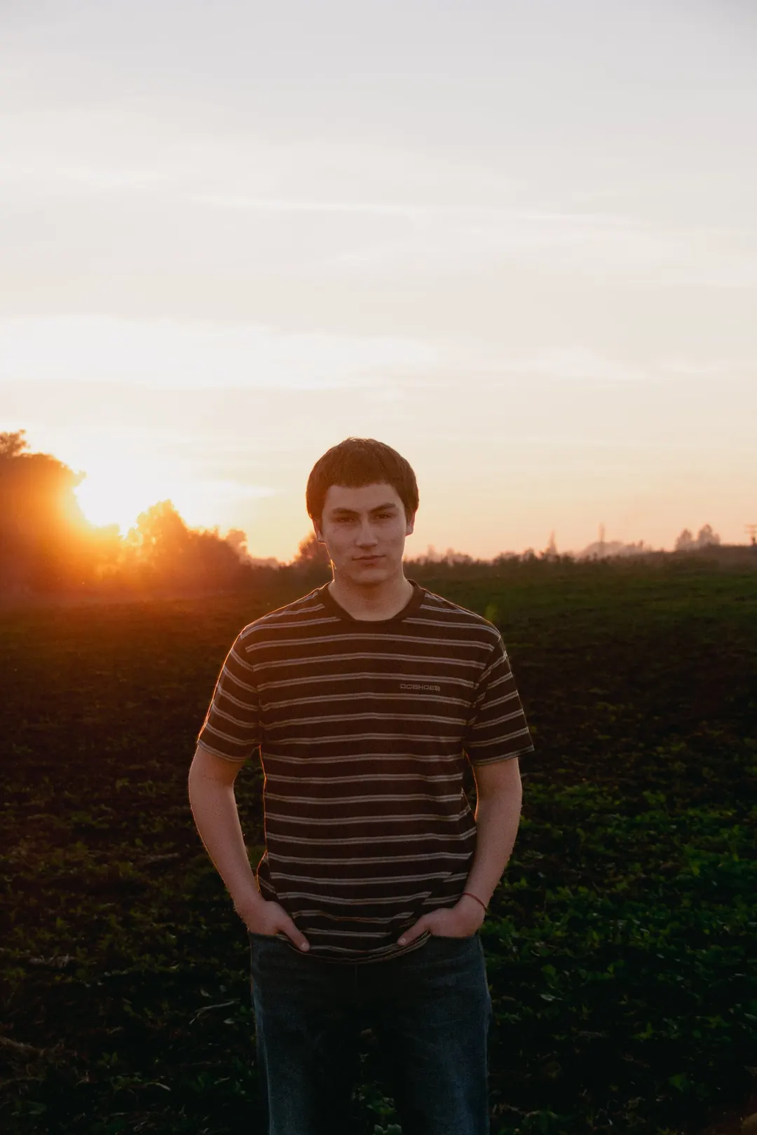 Joven a contraluz con el sol poniéndose