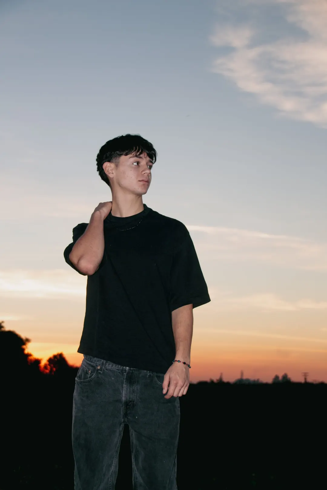 Joven contra el cielo del atardecer