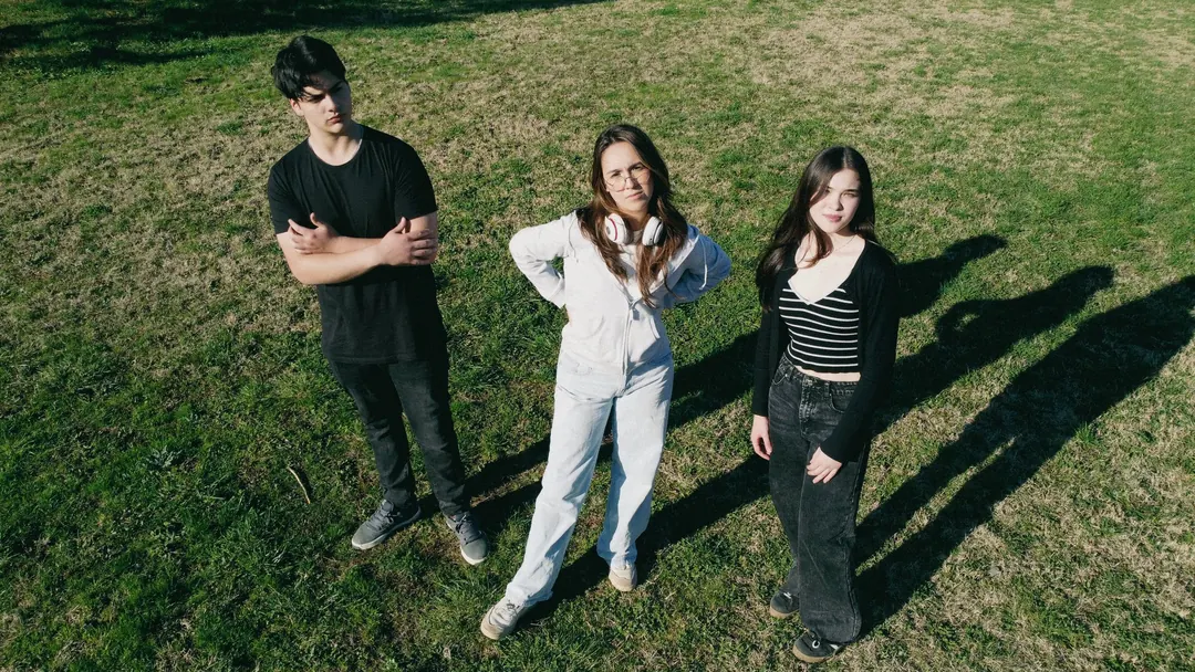 Tres jóvenes en el pasto, vistos desde arriba