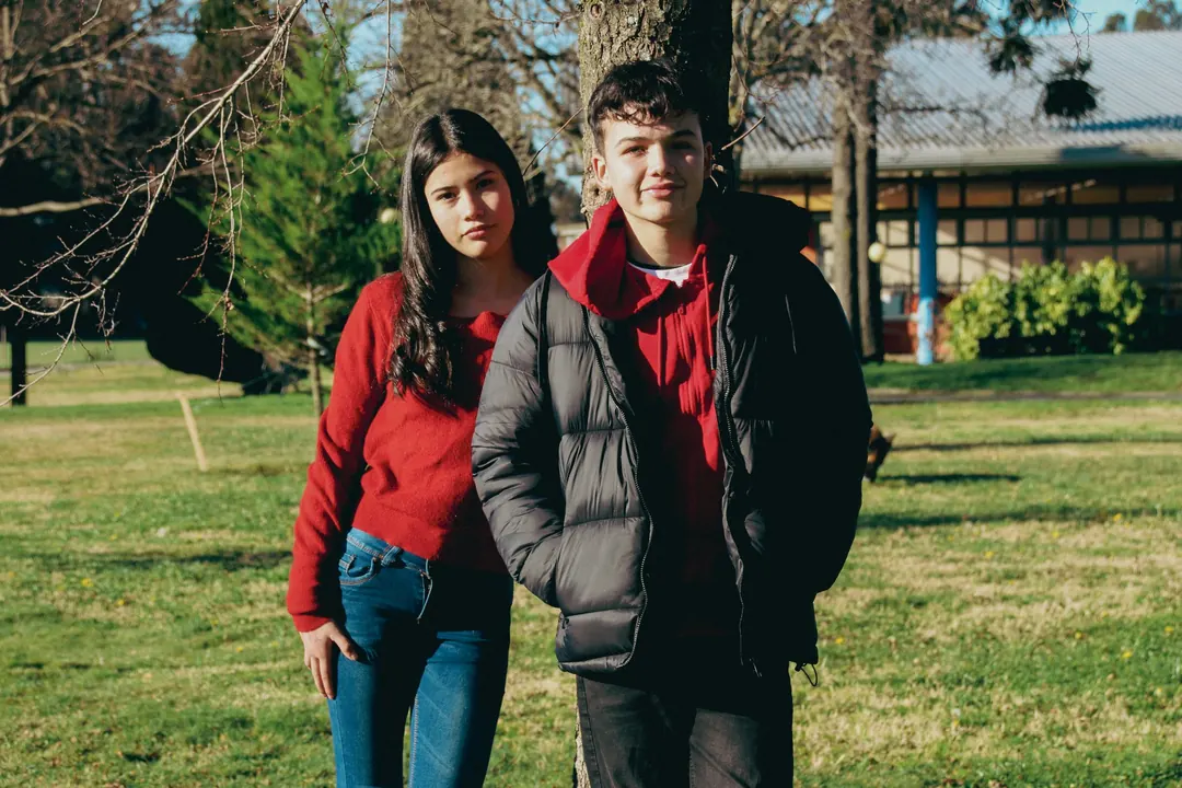 Dos jóvenes de pie en el pasto