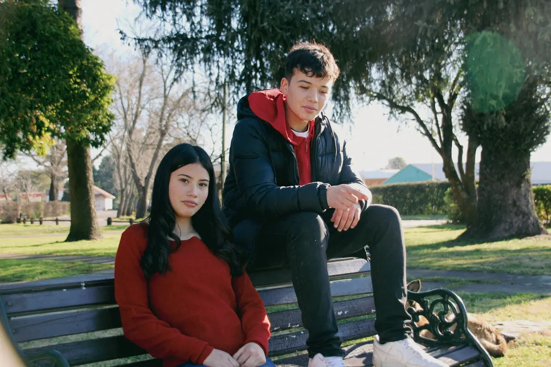 Dos jóvenes sentados en una banca