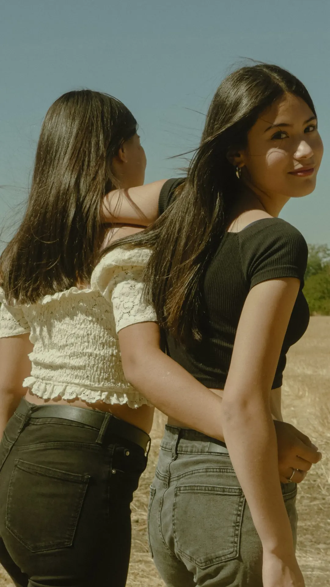 Dos jóvenes de espaldas en el campo